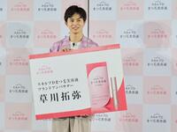 　アンバサダーの巨大名刺を受け取った草川拓弥