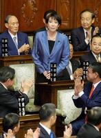 　衆院本会議で第１０４代首相に指名され、起立する自民党の高市早苗総裁。後方が菅義偉氏＝２０２５年１０月