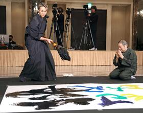 　書き初めパフォーマンスを行うＴＡＫＡＨＩＲＯ。右は吉川壽一氏（撮影・金田祐二）