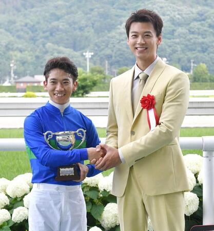 　プレゼンターを務めた竹内涼真（右）と笑顔で握手を交わす荻野