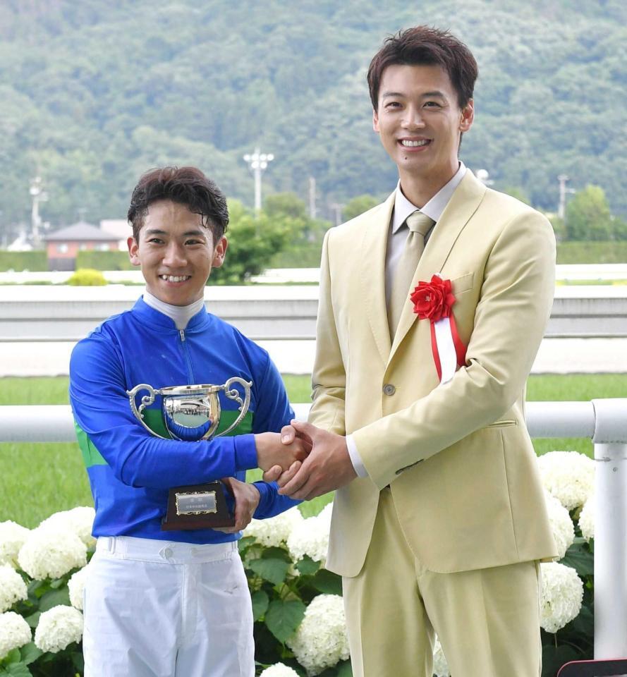 　プレゼンターを務めた竹内涼真（右）と笑顔で握手を交わす荻野