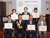 「カレー・オブ・ザ・イヤー２０２６」特別賞を受賞した石破茂前首相（下段右から２番目）と井上岳久学長（下段右から３番目）