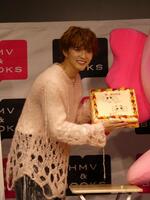 ケーキを手に笑顔の佐藤大樹