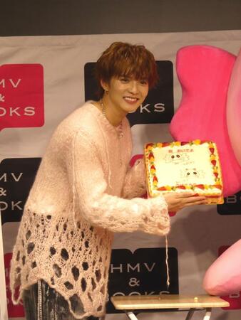 ケーキを手に笑顔の佐藤大樹