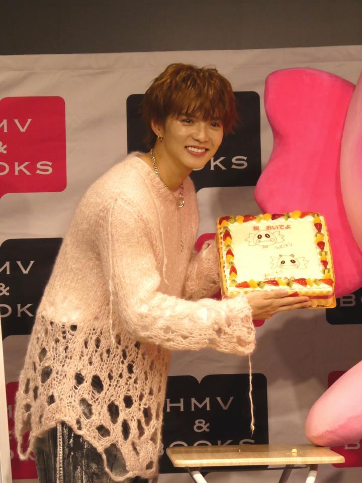 ケーキを手に笑顔の佐藤大樹