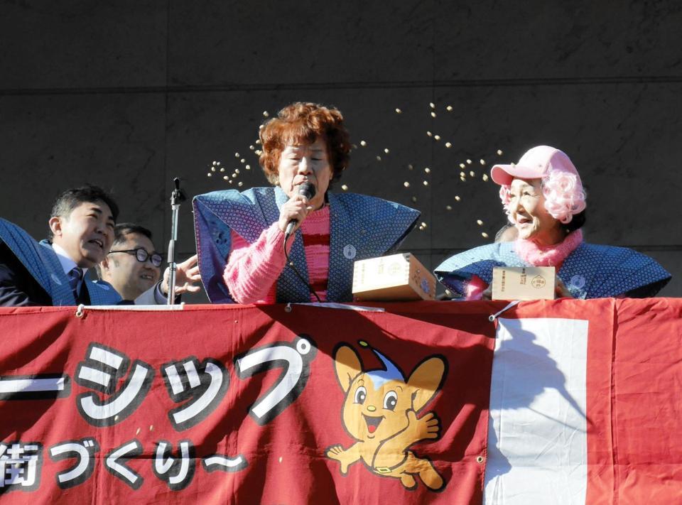 周囲に豆を浴びせられながら節分会の挨拶を行う林家ペー、パー子