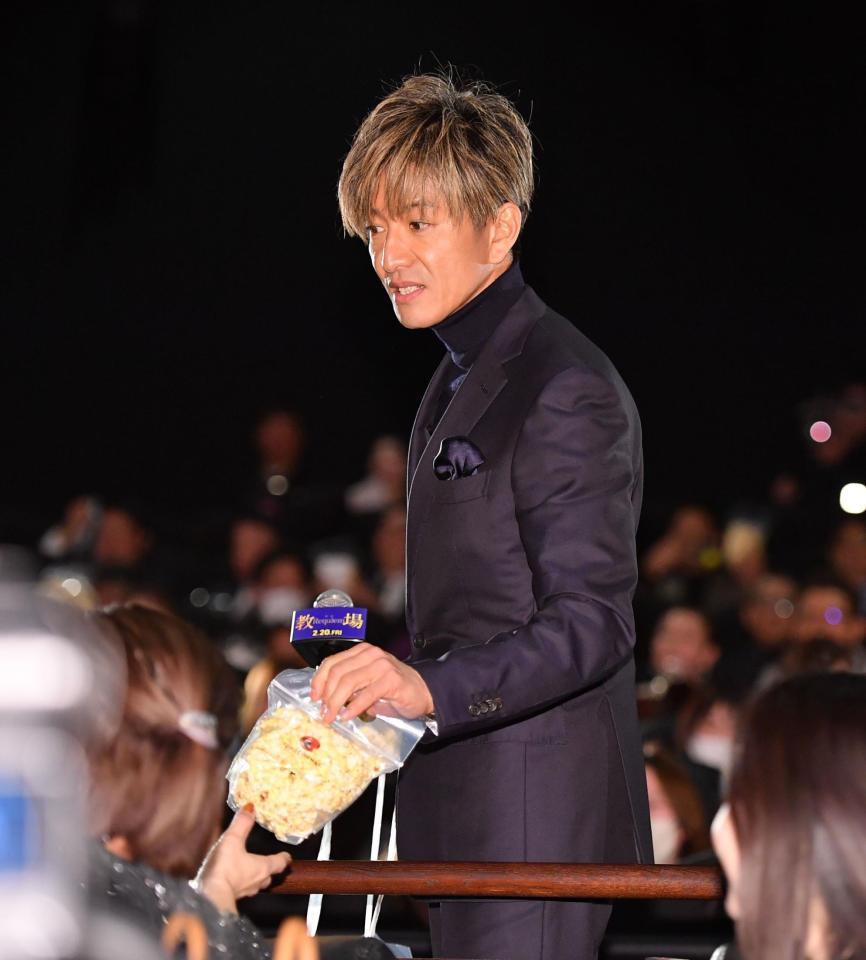 舞台あいさつで観客にポップコーンを振る舞う木村拓哉（撮影・開出牧）