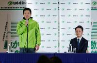 大阪府知事選で３回目の当選を決め、記者会見する吉村洋文氏。右は大阪市長選で再選を決めた横山英幸氏＝８日夜、大阪市内のホテル