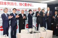 当確者の名前にバラを付ける自民党総裁の高市早苗首相（中央右）＝８日午後９時４３分、自民党本部（撮影・石井剣太郎）