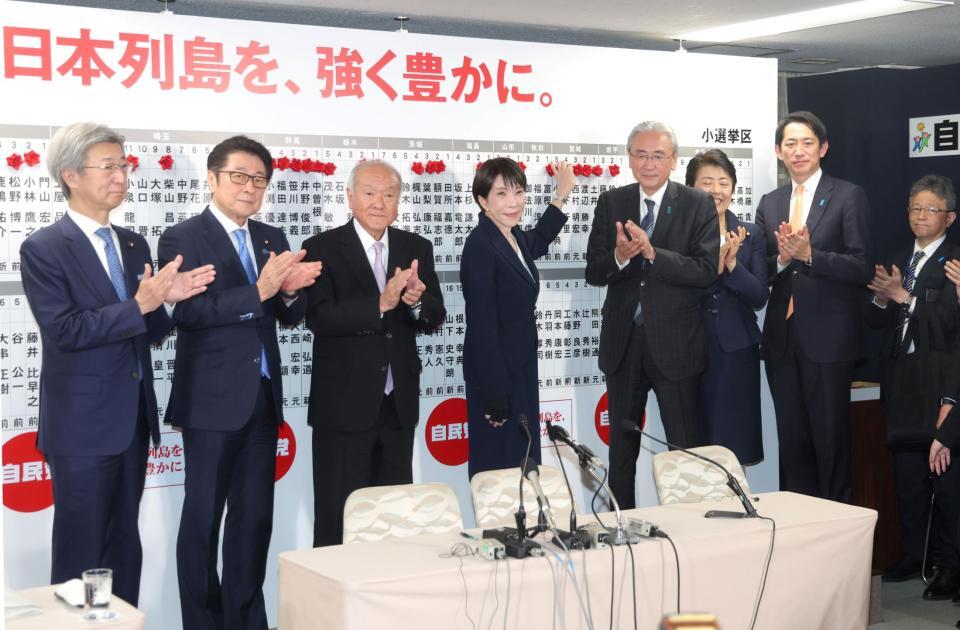 当確者の名前にバラを付ける自民党総裁の高市早苗首相（中央右）＝８日午後９時４３分、自民党本部（撮影・石井剣太郎）