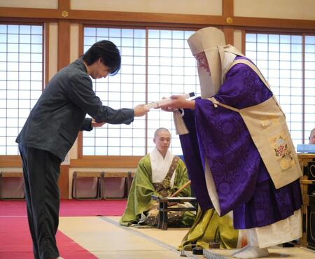 お札を受け取る岩橋玄樹＝東京・増上寺