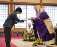 お札を受け取る岩橋玄樹＝東京・増上寺