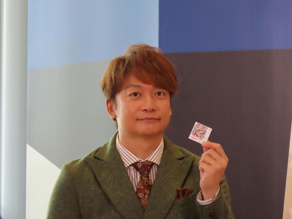 応援のチカラプロジェクトのシールを見せるスペシャルアンバサダー・香取慎吾