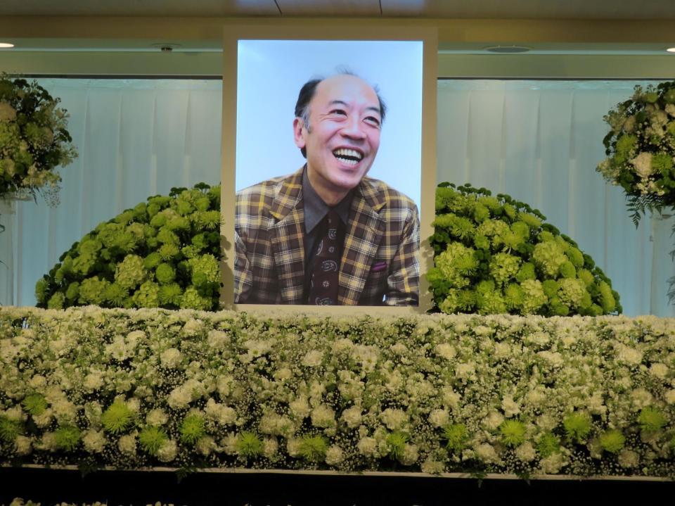 片岡亀蔵の笑顔の遺影を中心にグリーンを基調として彩られた祭壇