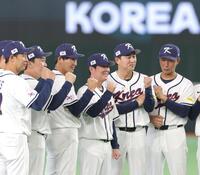 記念撮影で笑顔を浮かべ、ガッツポーズする韓国・柳智賢監督（中央）＝撮影・西岡正