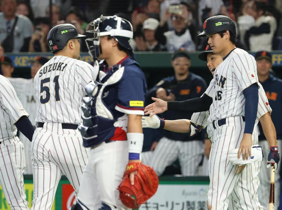 １回裏、２点本塁打を放った鈴木（左）を迎える二走大谷