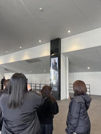 会場外に掲出された真矢さんの画像を撮影するファン