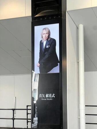 献花式の会場外に掲示された真矢さんの画像