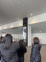 会場外に掲出された真矢さんの画像を撮影するファン