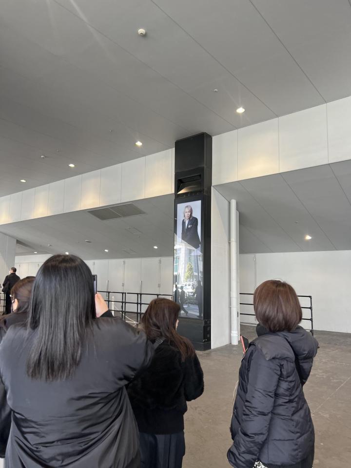 会場外に掲出された真矢さんの画像を撮影するファン