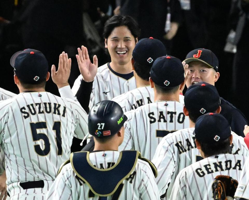 ７日の韓国戦に勝利し笑顔で鈴木（左）らナインを迎える大谷（中央）