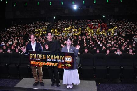 「ゴールデンカムイ」の人文字をバックに笑顔を見せる山﨑賢人（中央）と山田杏奈（右）