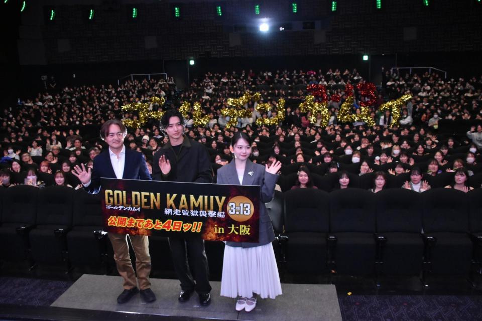 「ゴールデンカムイ」の人文字をバックに笑顔を見せる山﨑賢人（中央）と山田杏奈（右）