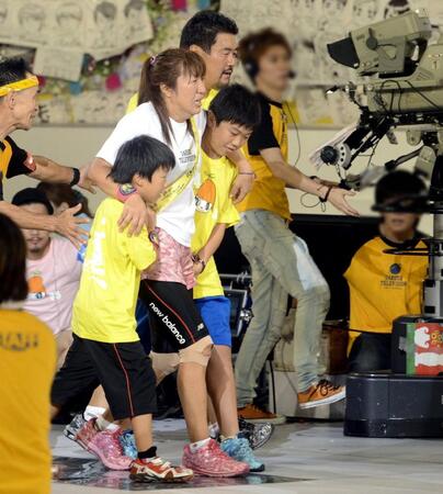 ２０１２年８月、「２４時間テレビ」チャリティランナーでゴールする北斗晶。次男・誠之介くん（手前）、長男・健之介くん（右）、夫の佐々木健介（右後方）　※一部写真を加工しています。