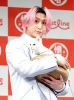 猫を抱く佐久間大介（撮影・西岡正）