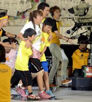 ２０１２年８月、「２４時間テレビ」チャリティランナーでゴールする北斗晶。次男・誠之介くん（手前）、長男・健之介くん（右）、夫の佐々木健介（右後方）　※一部写真を加工しています。