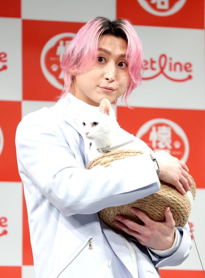 猫を抱く佐久間大介（撮影・西岡正）