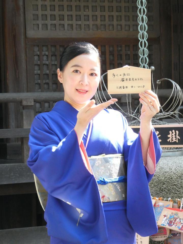 絵馬を持って撮影に応じるカン・ハンナ＝大圓寺