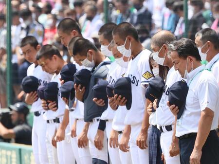 終戦の日を迎えた甲子園球場で、黙とうする高松商のナインら＝２０２２年８月