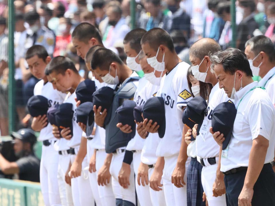終戦の日を迎えた甲子園球場で、黙とうする高松商のナインら＝２０２２年８月