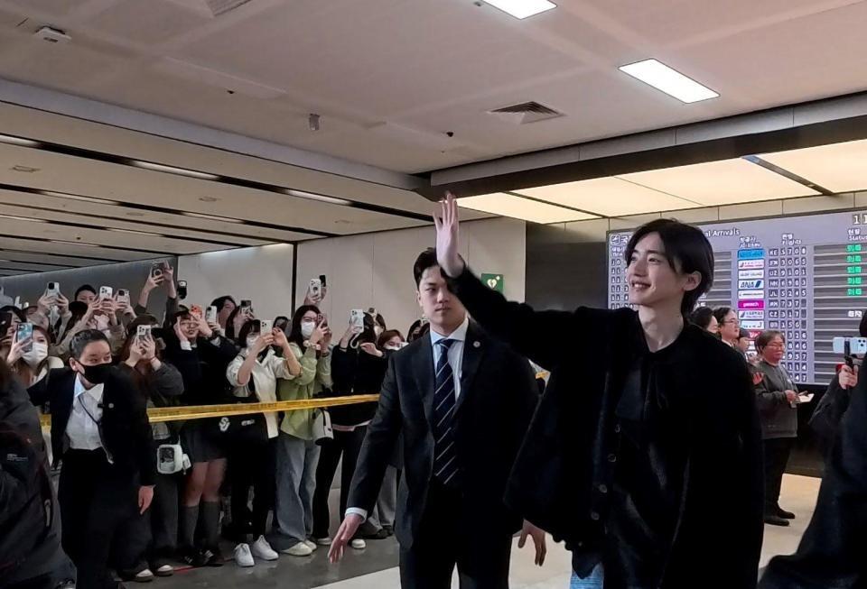 到着した空港で歓迎を受ける道枝駿佑©２０２６「君が最後に遺した歌」製作委員会