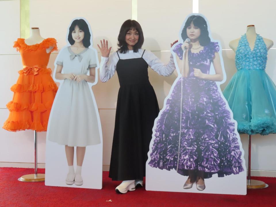 代表曲「まちぶせ」発表時のパネル（左）と紅白出場時のパネル（右）に囲まれて取材に応じる石川ひとみ