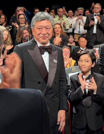 カンヌ国際映画祭で「箱の中の羊」の公式上映後、拍手を受ける是枝裕和監督（左）と桒木里夢さん＝16日、フランス・カンヌ（共同）
