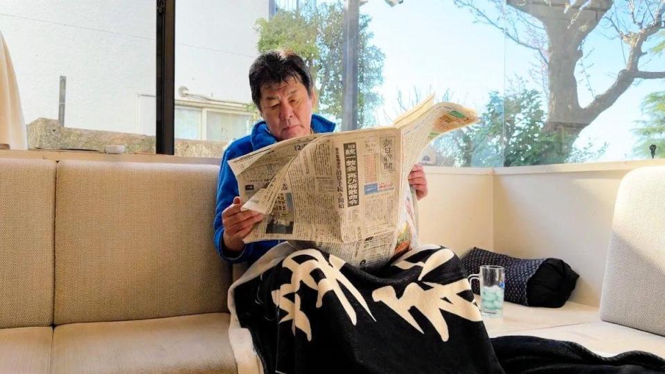 朝食を待つ間、新聞を読む赤井英和