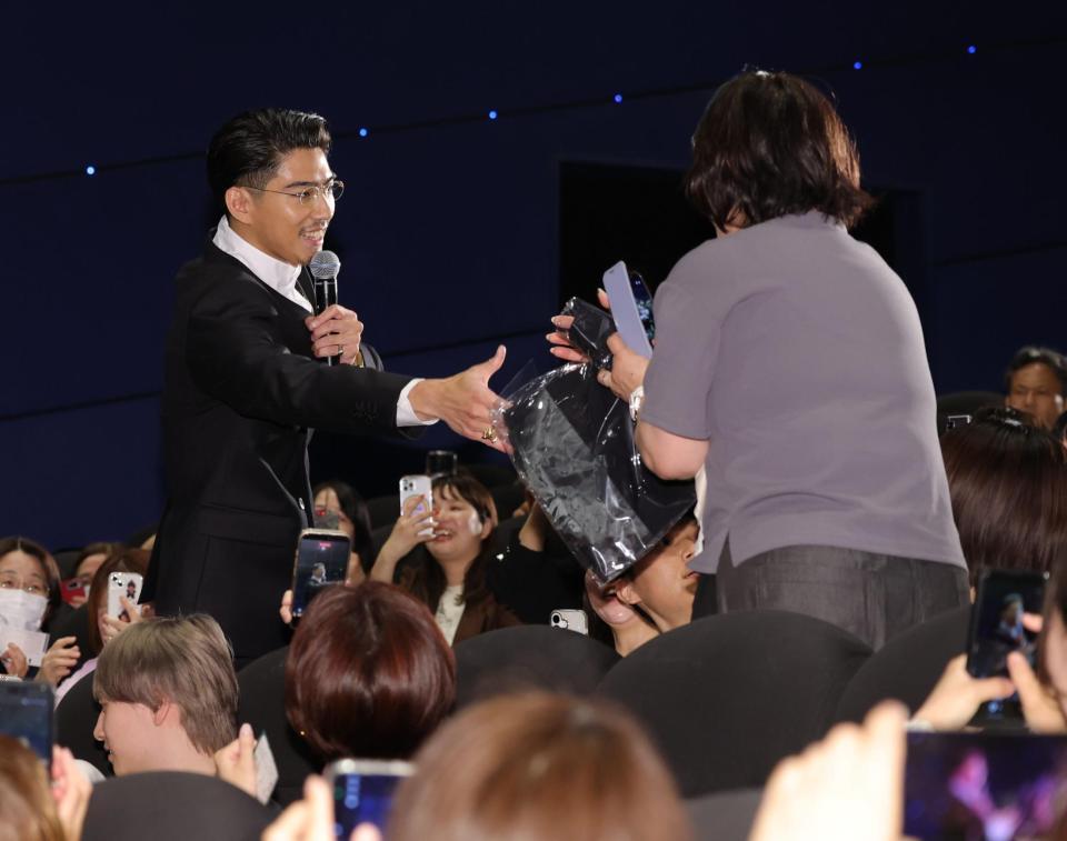 プレゼント抽選会の当選者に品物を手渡す賀来賢人（左）（撮影・棚橋慶太）