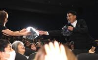 プレゼント抽選会の当選者に品物を手渡す賀来賢人（撮影・棚橋慶太）