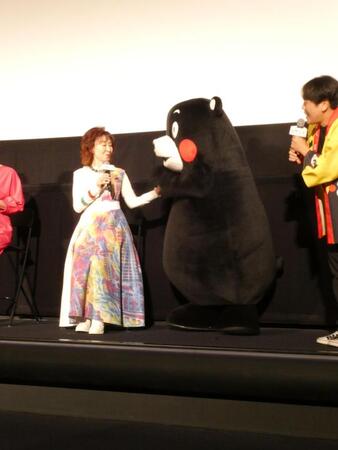 握手する（左から）三田佳子、くまモン、交流を見守る（右の）くまモン隊のお兄さん＝都内