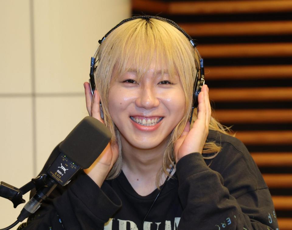 ヘッドホンに手を当て、笑顔を見せる岸谷蘭丸氏（撮影・棚橋慶太）