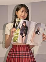 写真集のお気に入りのページを開き笑顔を見せるモーニング娘。の牧野真莉愛（撮影・持木克友）