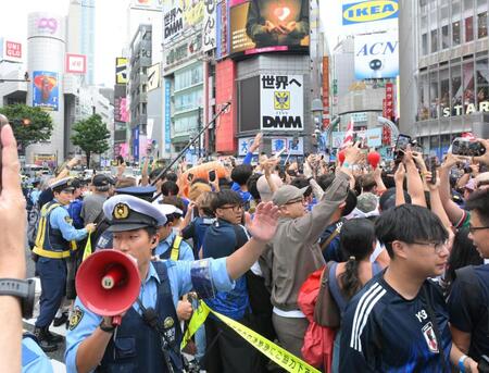 日本が１次Ｌ突破を決め、路上で盛り上がる人々と交通整理をする警官（撮影・伊藤笙子）