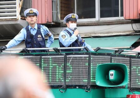路上で盛り上がるサポーターに注意喚起するＤＪポリス（撮影・伊藤笙子）