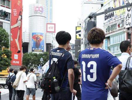スクランブル交差点で信号待ちをするサッカー日本代表ユニフォームを着たサポーター（撮影・伊藤笙子）