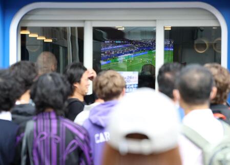 スポーツバーで放映されているスウェーデン戦を店外から見つめる人々（撮影・伊藤笙子）