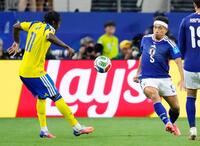 試合終了間際、競り合う長友（右）＝共同
