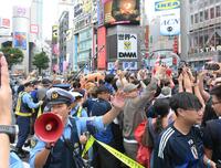 日本が１次Ｌ突破を決め、路上で盛り上がる人々と交通整理をする警官（撮影・伊藤笙子）