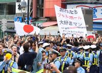 日本が１次Ｌ突破を決め、路上で盛り上がる人々と警戒する警察官（撮影・伊藤笙子）